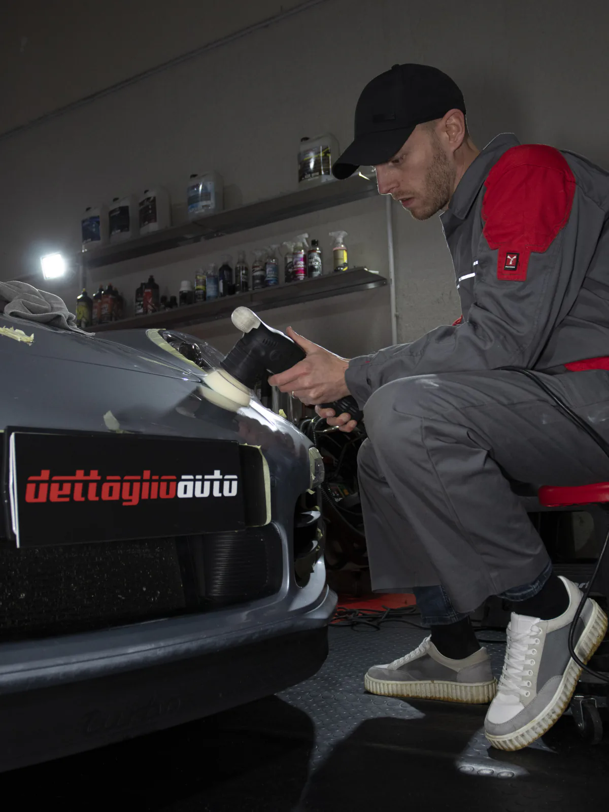 Lucidatura del paraurti di un’auto con lampada di ispezione.