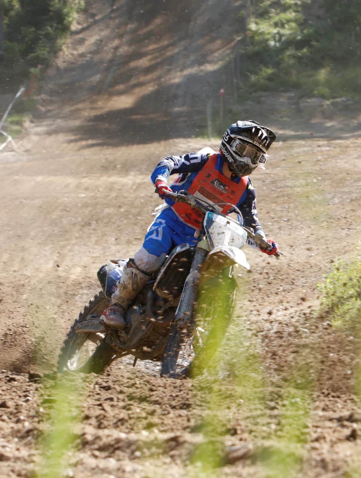Motocross in piega con la ruota posteriore che alza polvere.